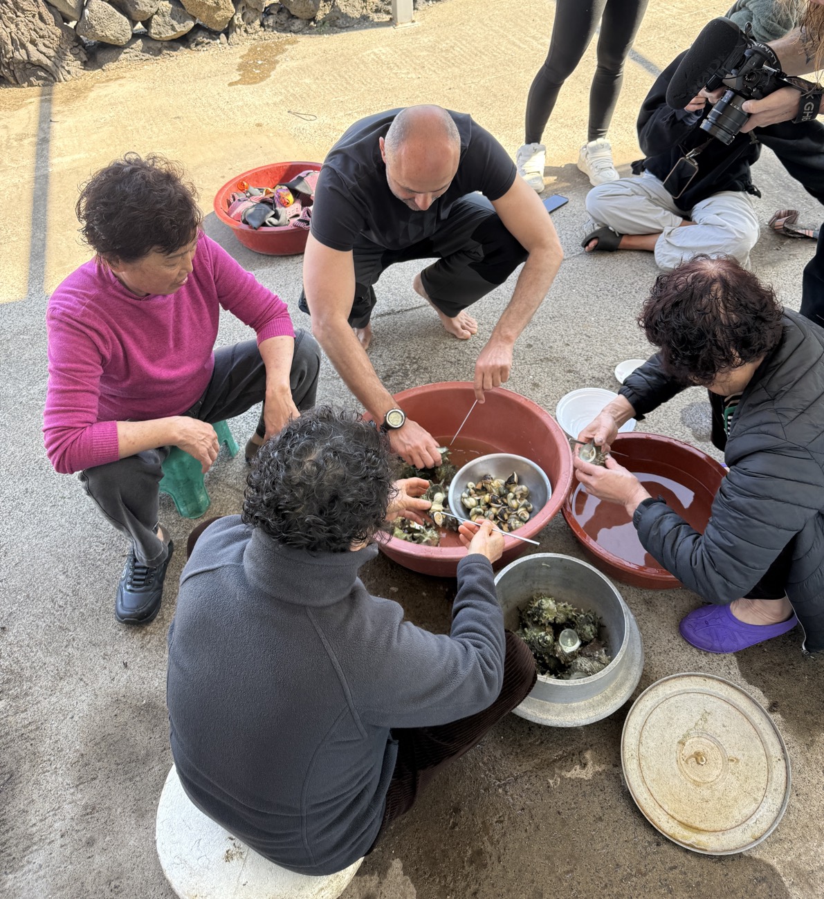 Guests and a haenyeo sorting the day's catch
